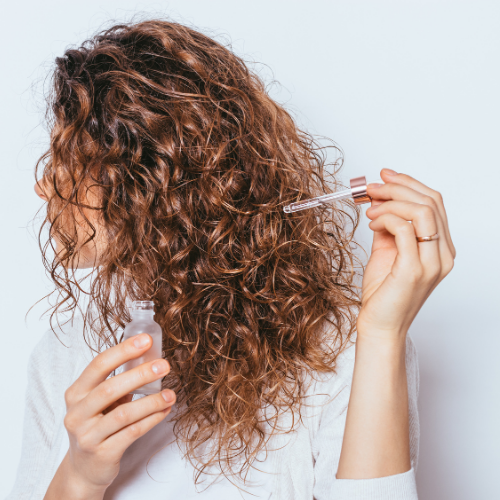 Woman applying scalp serum for thinning hair and sensitive scalp care | DR.MESO® Canada